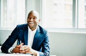 My Friend Laughed at My Small Business – Now He’s Asking for My Secret Smiling businessman in discussion at workstation in office