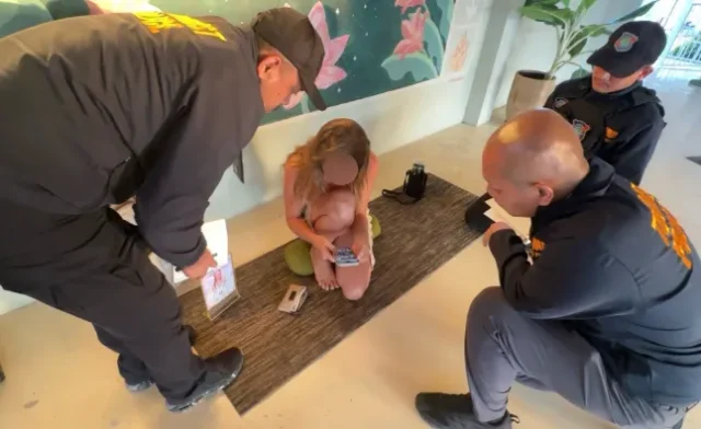 A 40-year-old Russian woman, Maria Shchetinina, was arrested for running unlicensed tantric sessions. Police raided the venue after complaints about “sexually indecent” online promotions. She allegedly violated Thailand’s foreign employment laws by working outside her permit. Authorities confiscated teaching materials and promotional items for investigation. The arrest mirrors another similar case on the island earlier this year. Arrest Over Tantric Lessons A Russian national, Maria Shchetinina, also known as Maria Sly Love, has been arrested in Koh Phangan after authorities accused her of running weekly tantric classes for tourists. The sessions, held behind the Ethos restaurant, reportedly cost 400 baht and included meditation, tantric massage, and what she described as “sacred sexuality.” How Police Intervened Police officers raided the area on 4 November following complaints about online adverts that residents considered inappropriate. Body-camera footage captured officers entering the room while a class was underway, with students seated cross-legged on yoga mats as Shchetinina led the session. During the inspection, officers reviewed her passport and work permit, which listed her occupation as a customer relations manager for a property management company. Authorities said the activities she was performing were outside the scope of her authorised work. Charges and Seized Materials Police Lieutenant Colonel Winit Boonchit confirmed that the suspect was charged with working illegally and conducting classes without official permission. She was taken to Koh Phangan Police Station for further questioning. Investigators also seized her notebooks, flyers, enrolment slips, and promotional materials featuring her photo and QR code—items used to market the sessions to tourists. Growing Concern Over Similar Activities Officials say the case was triggered by rising concerns from locals about “risque” social media promotions targeting visitors. The incident comes months after a Polish YouTuber was also arrested for organising “sex yoga” lessons on the same island. A Popular Hub for Spiritual Tourism Koh Phangan, known globally for its relaxed atmosphere, spiritual retreats, and vibrant nightlife, continues to attract yoga lovers, backpackers, and festival-goers. However, authorities are now paying closer attention to activities that may breach cultural norms or violate Thailand’s strict employment laws.